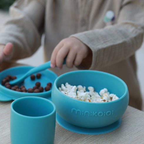 Minikoioi silicone BLW feeding set in blush pink with suction plate, bib, and spoon.