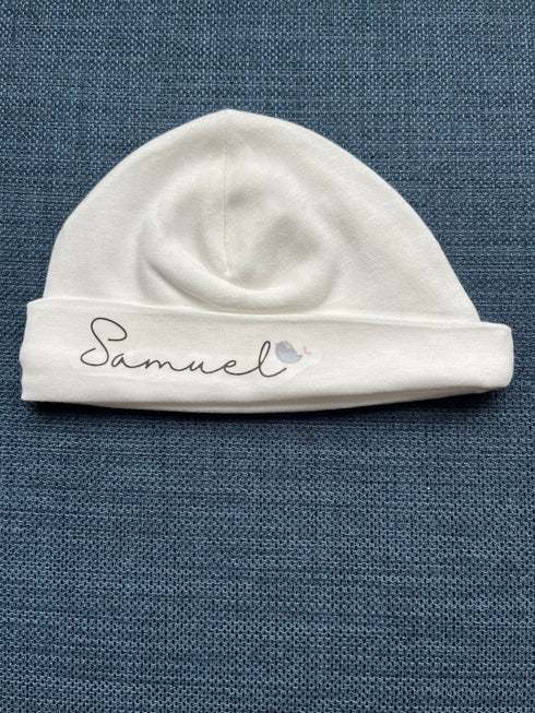 Custom name hat made from premium Prima cotton, displayed in a stylish neutral color with personalized embroidered text on the front.