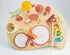 Interactive toddler music table in soft pastel with multiple percussion features: drum, xylophone, cymbal, bell, scraper.